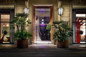 a building with two potted plants in front of a door at The Poet Hotel in La Spezia