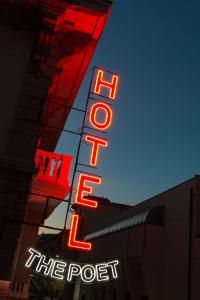 a neon sign for the post on the side of a building at The Poet Hotel in La Spezia