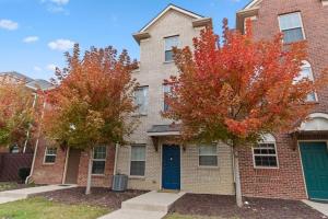 a brick house with a blue door and two trees at Affordable 2-BR Heart of Detroit in Detroit