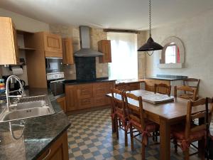 a kitchen with a wooden table and a dining room at La Ferme de l'Abbaye in Silli-en-Gouffern