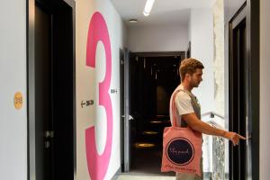a man holding a pink bag in a hallway at The Poet Hotel in La Spezia