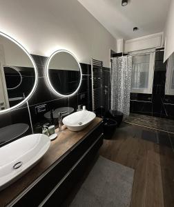 a black and white bathroom with two sinks and a shower at Green Apartment in Pioltello