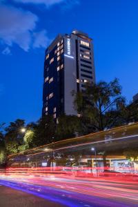 ein hohes Gebäude in der Nacht mit Lichtstreifen in der Unterkunft Hotel York Luxury Suites Medellin by Preferred in Medellín