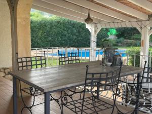 een houten tafel en stoelen op een patio bij Nice holiday house with pool at La Sella Golf between Denia and Javea in Pedreguer
