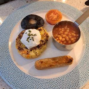 a plate of food with doughnuts and beans on a table at Waterfront House in Dartmouth