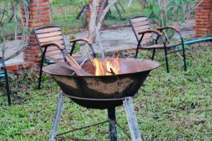 a fire pit in a yard with two chairs at Bat Rice Resort in Battambang