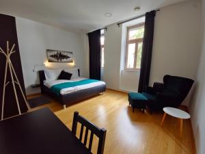 Argo Apartments في ليوبليانا: غرفة نوم بسرير وكرسي وطاولة
