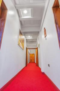 a hallway with a red carpet and a door at Ambrosia Heights in Entebbe