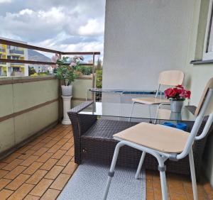 einen Balkon mit 2 Stühlen und einem Tisch auf dem Balkon in der Unterkunft BrightCenterApartment in Graz