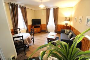 ein Wohnzimmer mit einem Sofa und einem Tisch in der Unterkunft Appartement dans Maison in Plainfaing