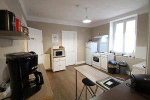 a kitchen with white appliances and a table in it at Appartement dans Maison in Plainfaing