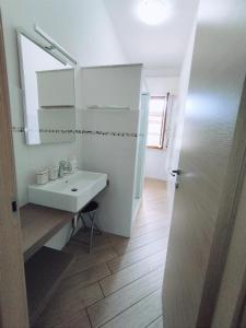 a white bathroom with a sink and a mirror at Big's house in Ceriale