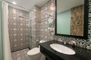 河内Downtown Hostel & Rooftop Bar的浴室里有洗手池、马桶和镜子。 更多21张照片