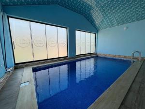a swimming pool in a building with windows at Topchu Forest Ismayilli in Topçu