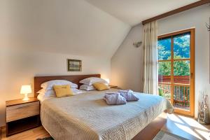 a bedroom with a large bed with a window at Mountain house Rupicapra with Sauna and Outdoor Hot Tub in Kostel