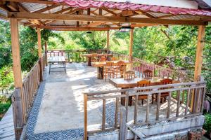 a wooden pavilion with tables and wooden tables at Bat Rice Resort in Battambang