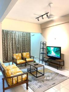 ein Wohnzimmer mit Sofas und einem Flachbild-TV in der Unterkunft PD Perdana Resort ASMAHOMESTAY in Port Dickson