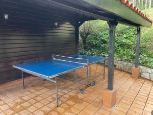 una mesa de ping pong en el patio en Cabaña de Caldones, 