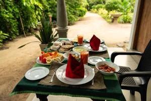 una mesa cubierta con platos de comida y servilletas rojas en Midigama Inn en Ahangama