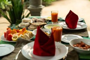 a table topped with plates of food with red napkins at Midigama Inn in Ahangama