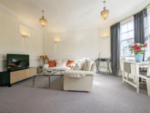 a living room with a couch and a tv at 5 The Clock House in Midhurst