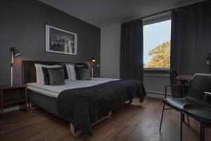 een slaapkamer met een groot bed en een raam bij Hotell Skövde in Skövde