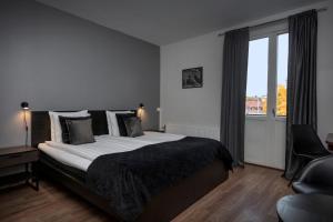 een slaapkamer met een groot bed en een raam bij Hotell Skövde in Skövde