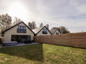 a house with a wooden fence in a yard at Maritos in Holywell