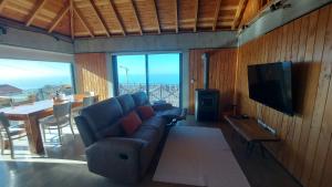 een woonkamer met een bank, een tv en een tafel bij Casa Pereirinha in Estreito da Calheta