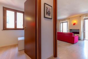 una porta aperta su un soggiorno con divano rosso di [Como-Blevio] Suite lake view + private garage a Blevio