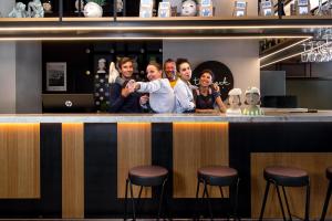 a group of people standing behind a bar at The Poet Hotel in La Spezia