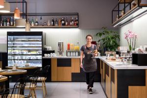 a woman standing at a counter in a restaurant at The Poet Hotel in La Spezia
