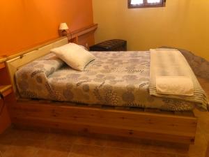 ein Schlafzimmer mit einem Holzbett mit einem Kissen darauf in der Unterkunft Casa Rural La Curva in Barajas de Gredos