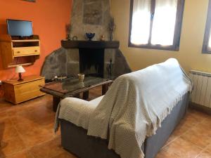ein Wohnzimmer mit einem Tisch und einem Kamin in der Unterkunft Casa Rural La Curva in Barajas de Gredos