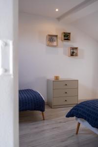 a bedroom with a bed and a dresser at Gîte de la Place classé 3 étoiles Centre Bourg WIFI Services prosConciergerie Comte des Cierges 
