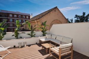 uma varanda com um sofá e cadeiras num edifício em San Nicolas Luxury Home with prívate terrace em Córdoba