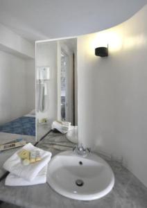 a bathroom with a sink and a mirror at Rodon Hotel in Chania Town
