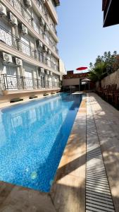 une grande piscine en face d'un bâtiment dans l'établissement DR. GREENS, à Antalya