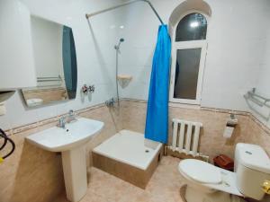 a bathroom with a sink and a toilet and a mirror at Hotel Zavq in Andijan