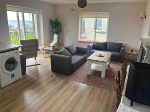 uma sala de estar com um sofá e uma mesa em Coastal Apartment Tramore em Waterford