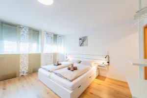 een witte slaapkamer met een wit bed en een raam bij Modern und Renoviert in Neurenberg