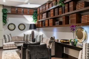 a living room with a couch and clocks on the wall at Hotel 93 Luxury Suites by Preferred in Bogotá