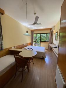 佛羅安那波里的住宿－Canto da Ilha，酒店客房带一张床、一张桌子和椅子