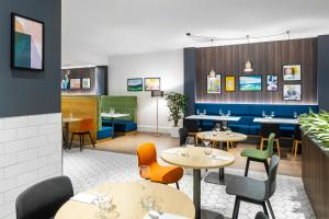 um restaurante com mesas e cadeiras num quarto em Holiday Inn Leicester City, an IHG Hotel em Leicester