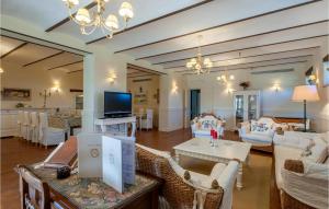 a living room with couches and a table and a tv at 6 Bedroom Awesome Home In Treia in Appignano
