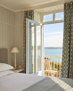 a bedroom with a bed and a view of the ocean at Le Grand Hotel des Bains & Spa - Bretagne in Locquirec +48 photos