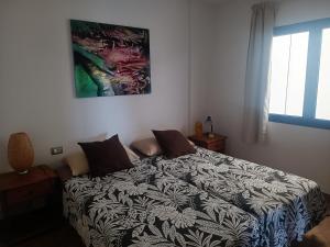 1 dormitorio con cama con edredón en Casa de Famara en Famara