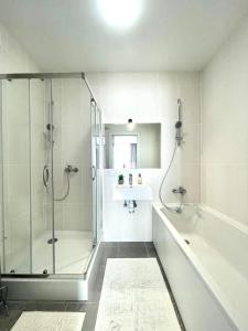 ein Badezimmer mit einer Dusche, einer Badewanne und einem Waschbecken in der Unterkunft Люкс апартаменти в затишному ЖК бізнес класу in Kiew