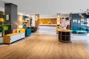 a lobby of a hotel with blue furniture and flowers at Holiday Inn Leicester City, an IHG Hotel in Leicester