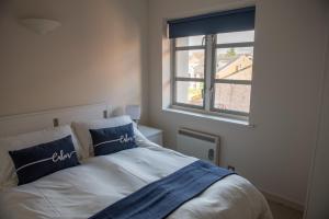a bedroom with a bed with blue and white pillows at Toothbrush Apartments - Central Ipswich St Peters St in Ipswich